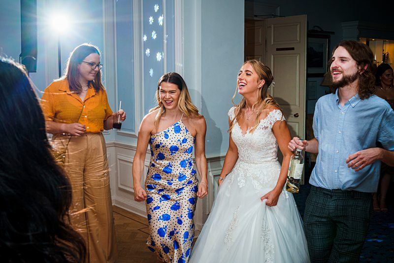 Bride and friends laughing at wedding reception.