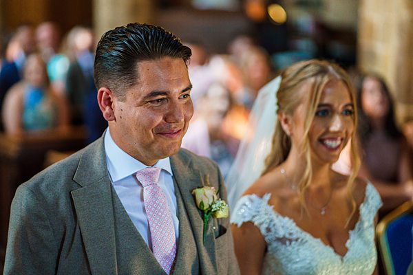 Bride and groom smiling in wedding ceremony.