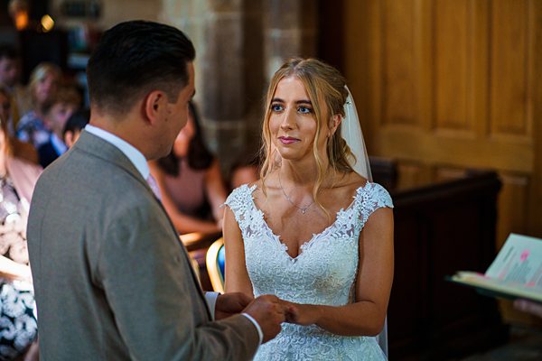 Bride and groom exchanging vows at wedding ceremony.