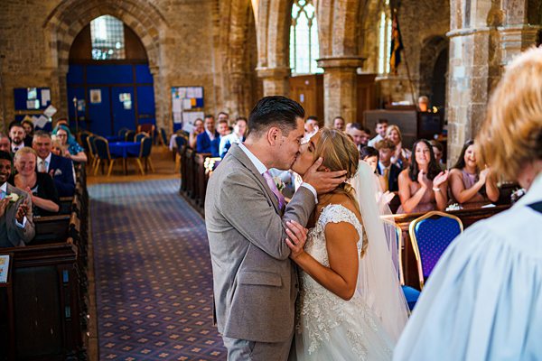 Bride and groom's first kiss at church wedding ceremony.