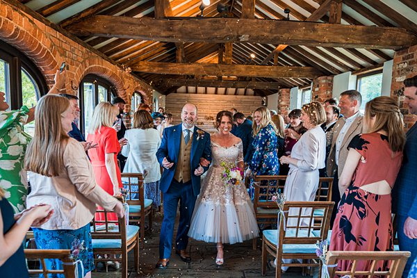 Joyful wedding couple walking down the aisle.