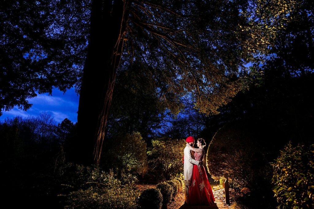 Couple in evening attire outdoors at night.