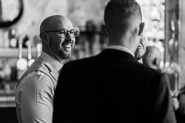 Two men conversing happily in a bar setting.