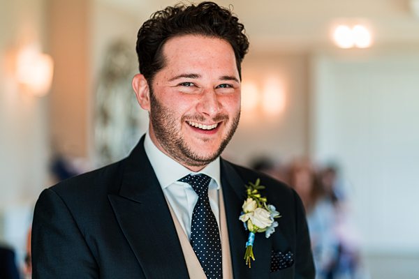 Happy groom in suit with boutonnière.
