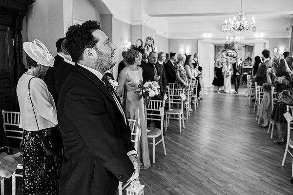 Guests at wedding ceremony in elegant venue.