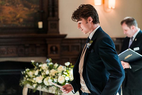 Groom reading vows at wedding ceremony.