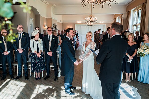 Couple holding hands at wedding ceremony.