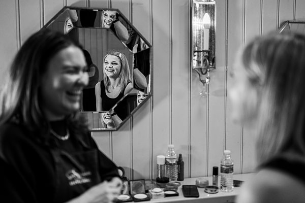Woman smiling in mirror, conversation, black and white photo.