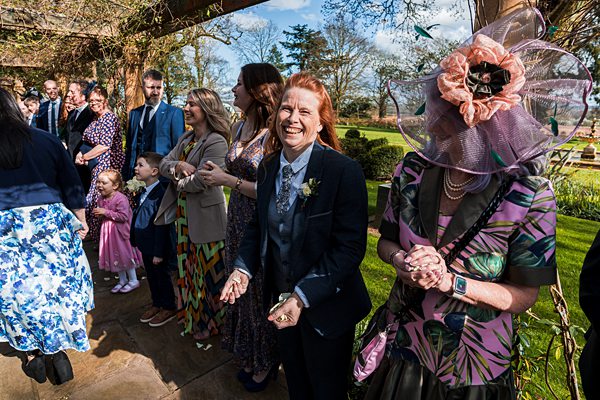 Guests smiling at a sunny garden wedding.