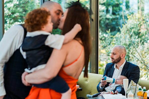 Family moment in a sunlit cafe setting.
