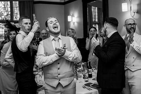 Guests laughing at lively wedding reception.