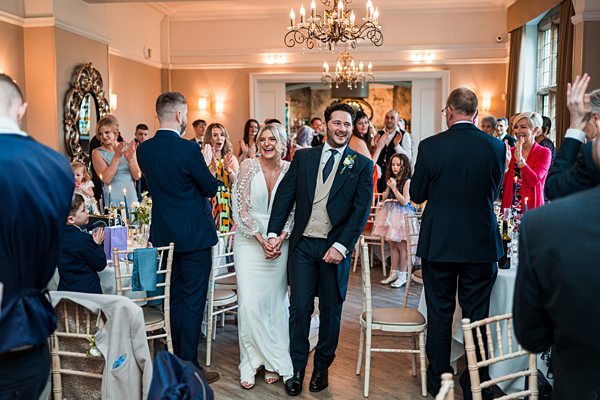 Couple's joyful wedding reception entrance.