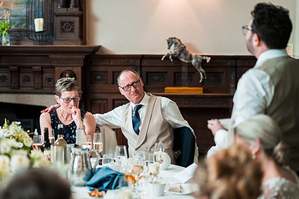 Guests laughing at wedding reception table.