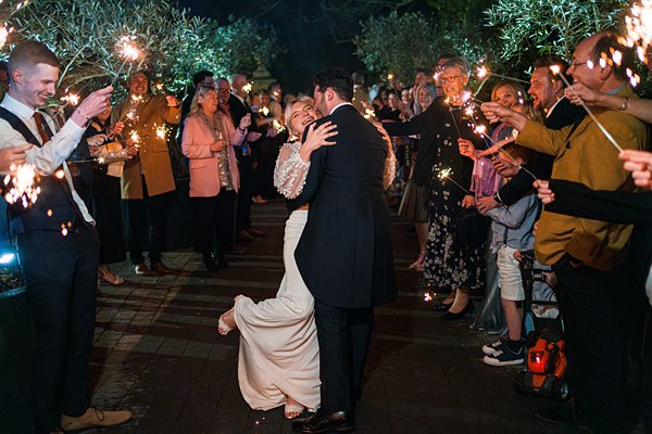 Couple's first dance with sparklers at night wedding.