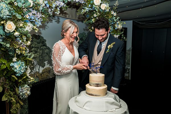 Bride and groom cutting cake at wedding reception.