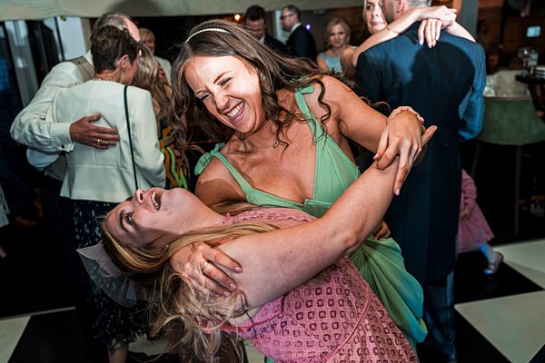 Women laughing and dancing at a celebration.