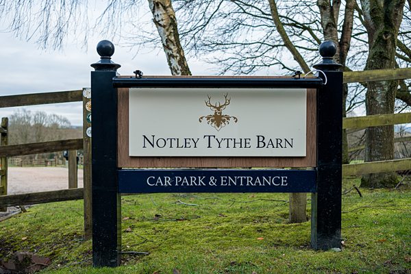 Notley Tythe Barn sign with car park and entrance directions.