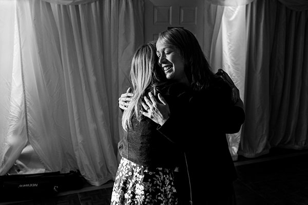 Two women embracing in joyful reunion, black and white photo.