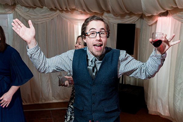 Man celebrating with wine at party.
