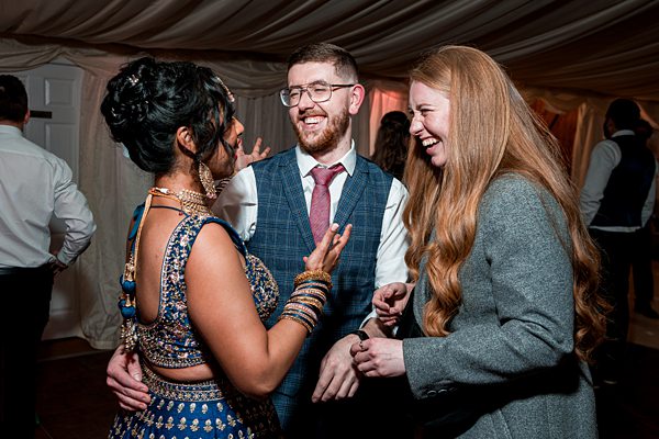 Diverse friends laughing at festive event.