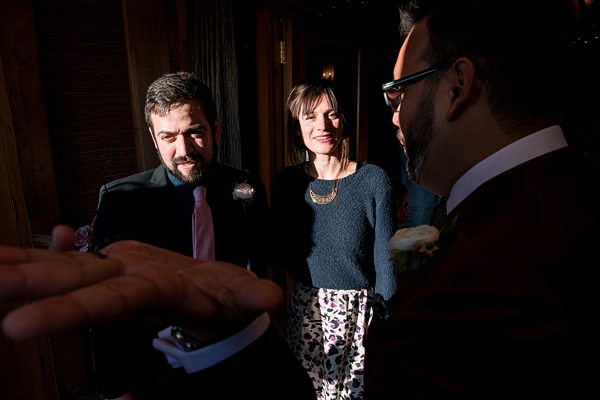 Three people enjoying conversation at an indoor event.