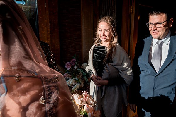 Guests smiling at wedding ceremony entrance.