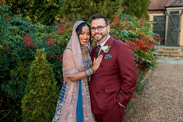 Couple in wedding attire smiling outdoors