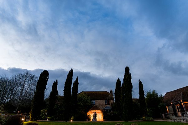 Twilight over an English country house with illuminated entrance.