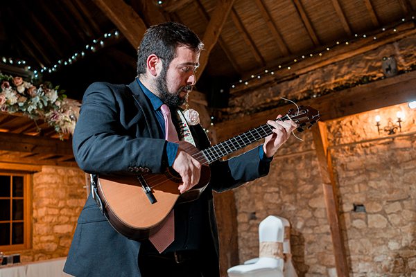 Man playing guitar at rustic venue.