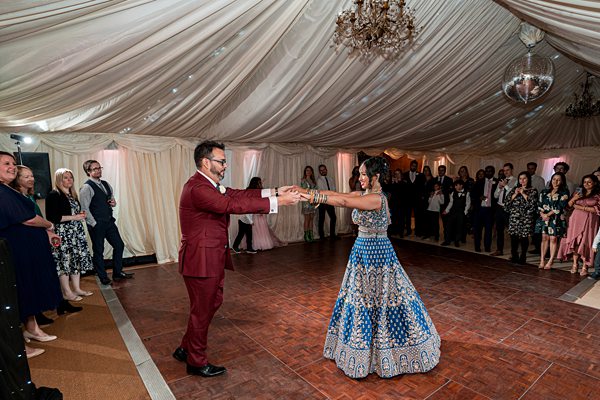 Couple dancing at wedding reception under tent.