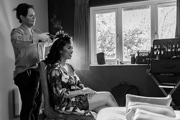 Woman getting hairstyle by professional in bright room