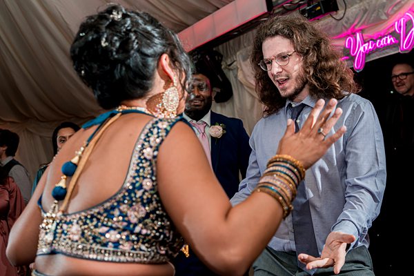 Guests dancing at multicultural wedding reception.