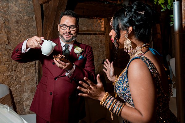 Man pouring tea at multicultural wedding celebration.