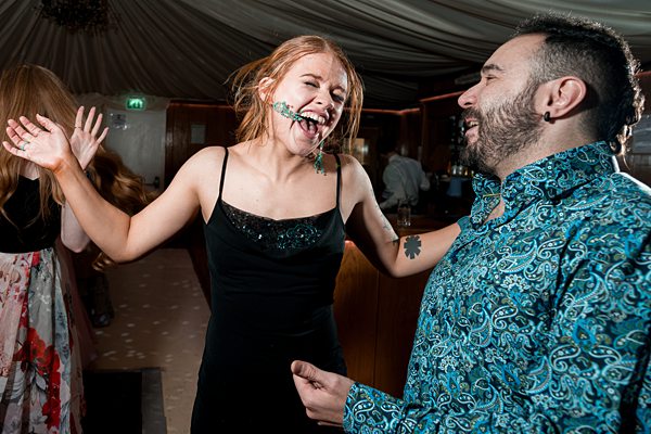 People laughing and dancing at party.