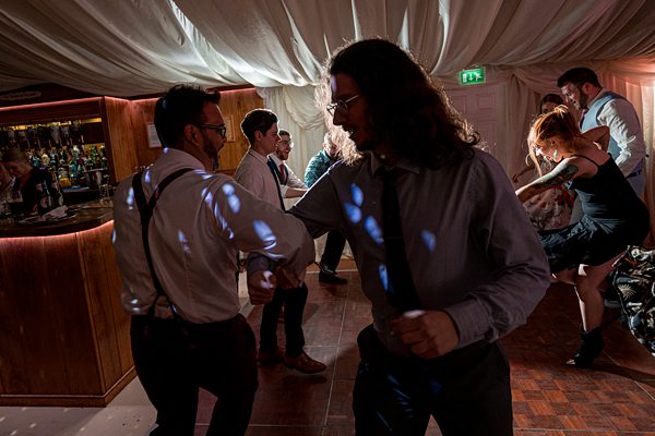Guests dancing at evening wedding reception.
