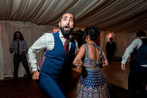 Guests dancing energetically at a wedding reception.