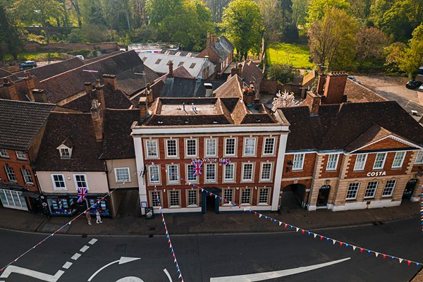 Aerial view of quaint UK town centre with bunting.
