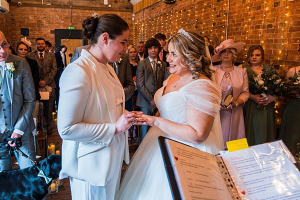 Bride and partner exchanging rings at wedding ceremony.