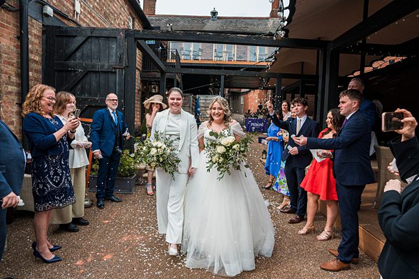 Bride and groom during confetti toss at wedding venue.