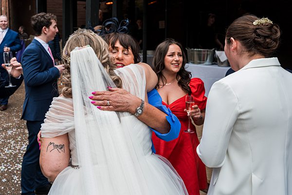 Joyful wedding guests embracing at a reception.