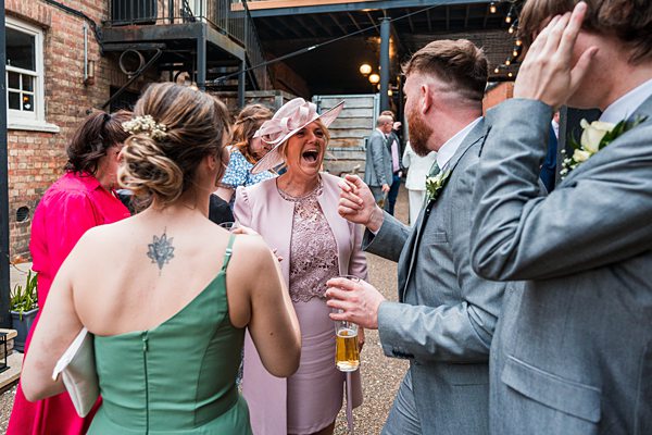 Guests laughing at outdoor wedding reception.