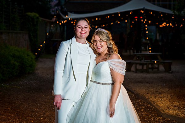 Two women dressed for a special occasion smiling outdoors.