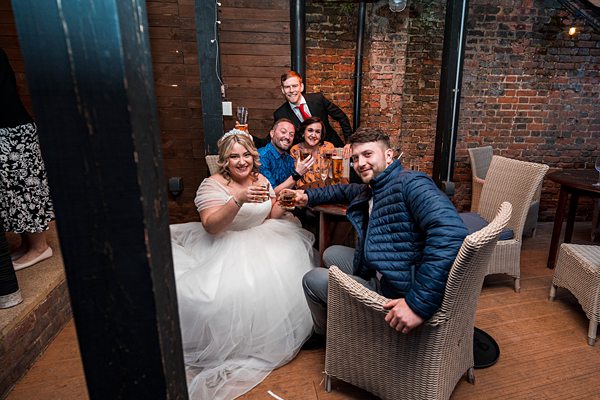 Group of people toasting at wedding reception.