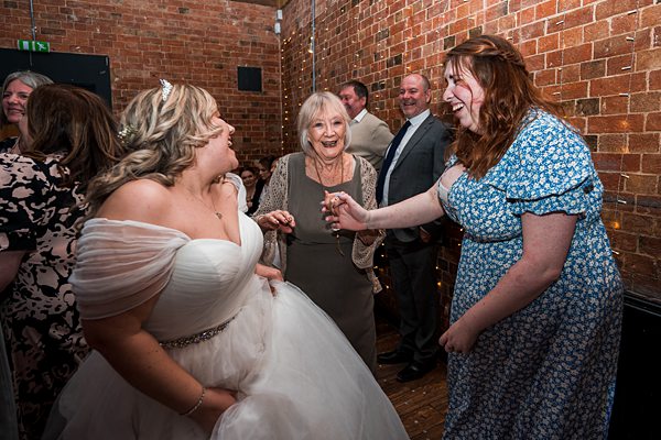 Joyful wedding guests dancing and celebrating.