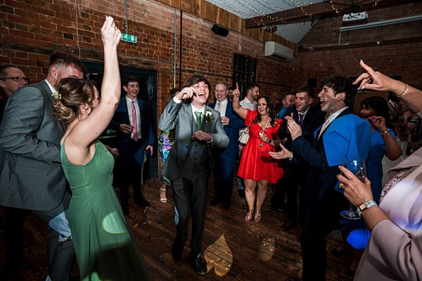 Joyful wedding dance celebration indoors.