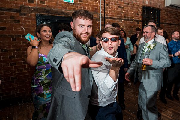 Men dancing at festive wedding reception.