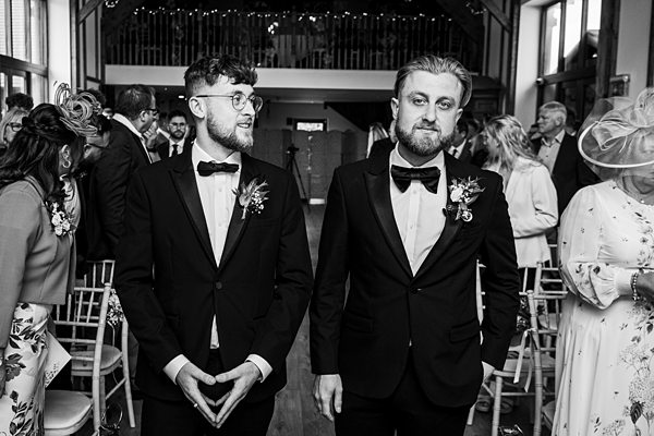 Groomsmen in tuxedos at wedding ceremony.