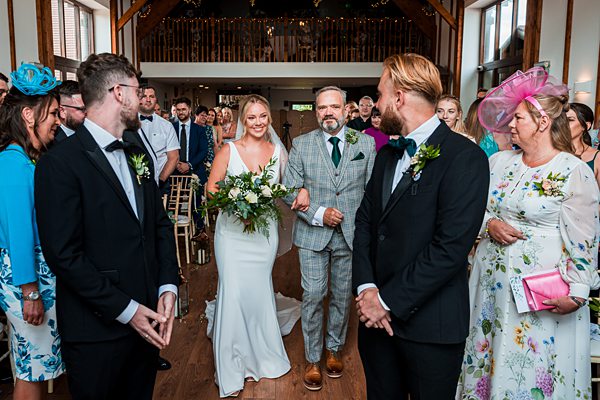 Bride and groom smiling during wedding ceremony.