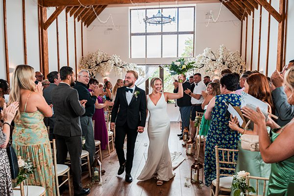 Joyful wedding couple walking down the aisle.