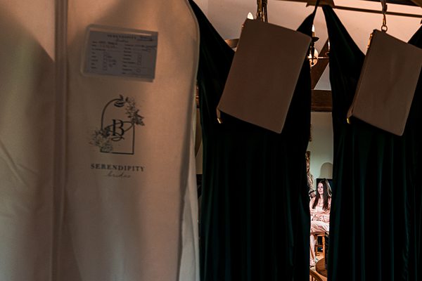 Woman in boutique with elegant dresses on display.